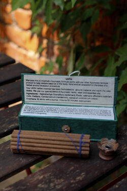 Zestaw kadzideł Vata - grube kadzidła, podstawka i zielone opakowanie kadzideł, leżą na stole na tle zieleni