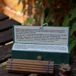 Zestaw kadzideł Vata - grube kadzidła, podstawka i zielone opakowanie kadzideł, leżą na stole na tle zieleni