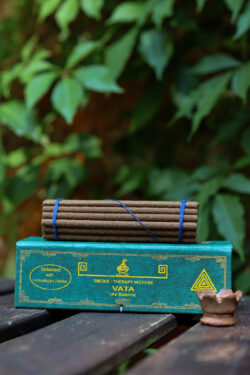 Zestaw kadzideł Vata - grube kadzidła, podstawka i zielone opakowanie kadzideł, leżą na stole na tle zieleni