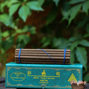 Zestaw kadzideł Vata - grube kadzidła, podstawka i zielone opakowanie kadzideł, leżą na stole na tle zieleni