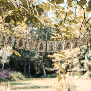 Girlanda z papieru czerpanego lokta z wizerunkiem Ganeshy zawieszona wśród drzew