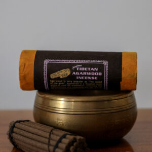 Kadzidełka Tibetan Agarwood - drzewo agarowe - leżą na drewnianym stole, obok misa dźwiękowa i podstawka