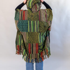 Kobieta z zielonym patchworym ponczo z kapturem na białym tle