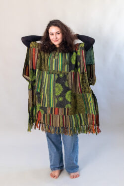 Kobieta z zielonym patchworym ponczo z kapturem na białym tle