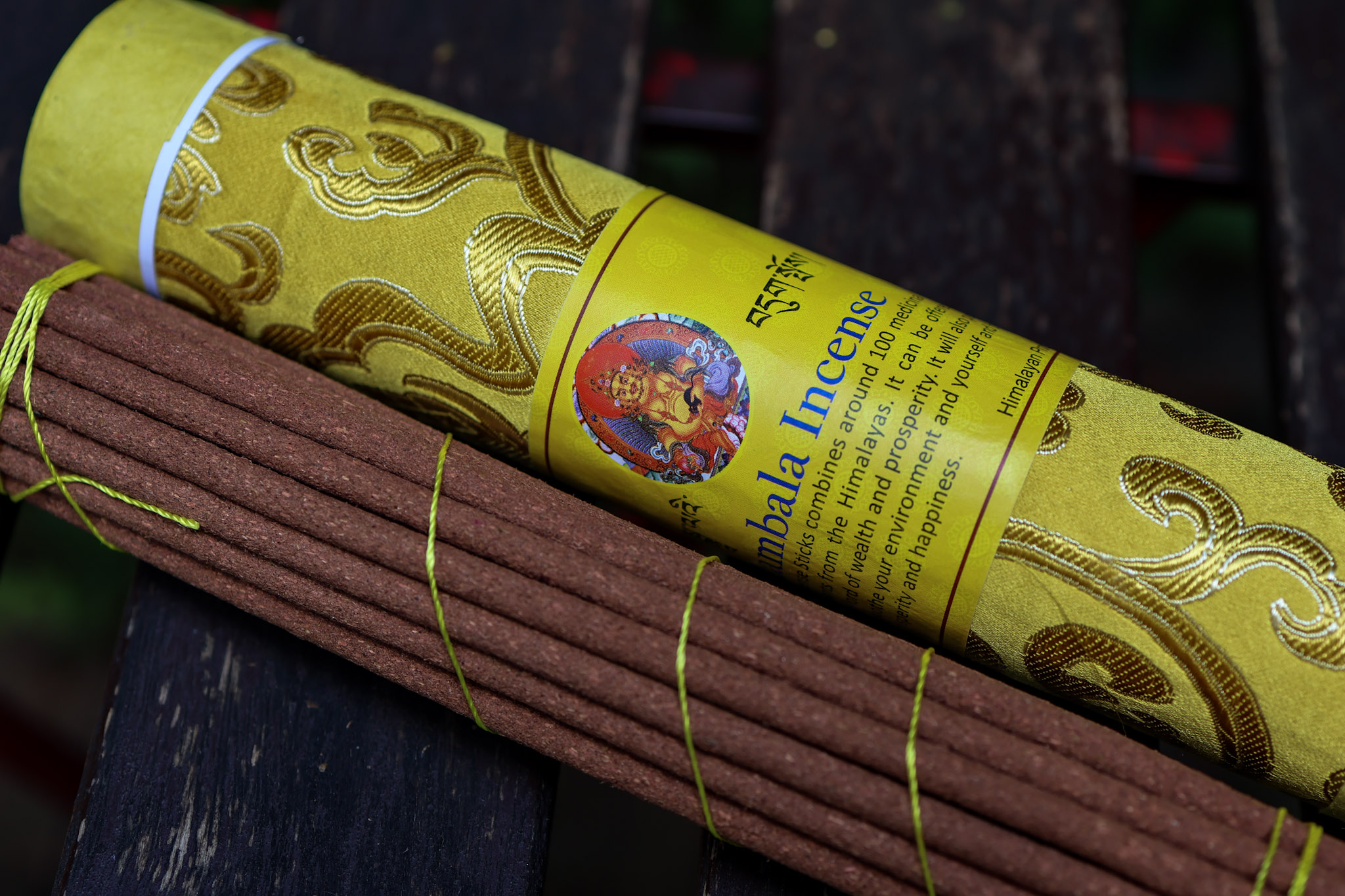 Grube bhutańskie kadzidła leżą na stole, obok dekoracyjna tuba kadzideł Zambala Incense