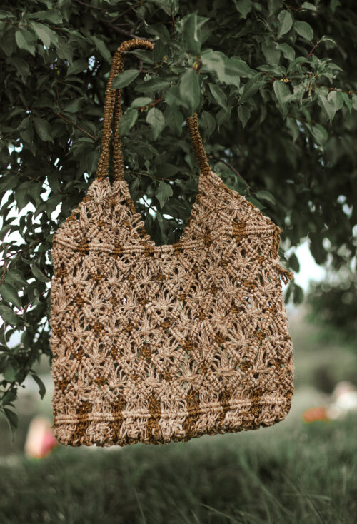 Beżowa boho torebka z konopi zawieszona wśród drzew