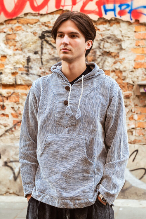 Bluza w jodełkę Mężczyzna w bluzie w jodełkę stoi na tle ceglanego muru