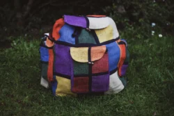 Kolorowy plecka z konopi z patchworkowych prostokątów leżący na zielonej trawie