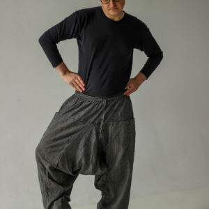 Mężczyzna w czarno-białych szarawarach w paski na białym tle