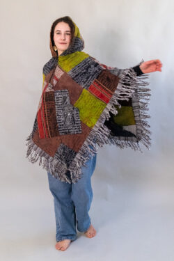 Kobieta w patchworkowym ponczo i jeansach na białym tle