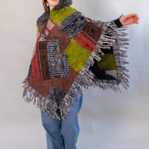 Kobieta w patchworkowym ponczo i jeansach na białym tle