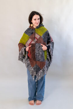 Kobieta w patchworkowym ponczo i jeansach na białym tle