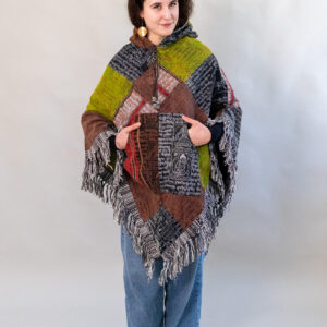 Kobieta w patchworkowym ponczo i jeansach na białym tle