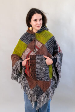 Kobieta w kolorowym patchworkowym ponczo z rękami w kieszeniach na białym tle