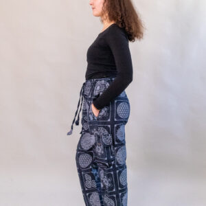 Kobieta w czarnych spodniach z nepalskimi symbolami