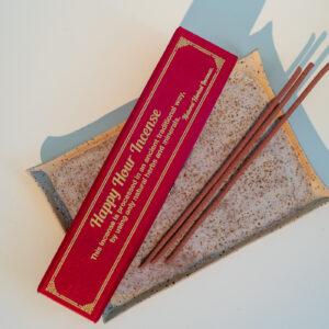 Nepalskie grube kadzidła Happy Hour w ozdobnym czerwonym pudełku, położone na tacy