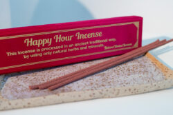 Nepalskie grube kadzidła Happy Hour w ozdobnym czerwonym pudełku, położone na tacy