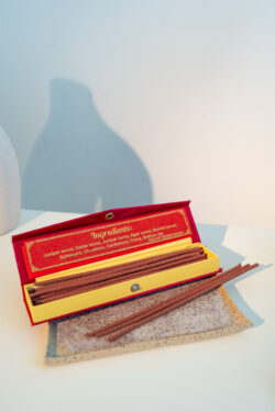 Nepalskie grube kadzidła Happy Hour w ozdobnym czerwonym pudełku, położone na tacy