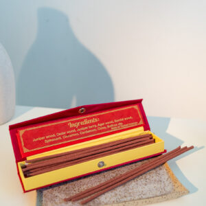 Nepalskie grube kadzidła Happy Hour w ozdobnym czerwonym pudełku, położone na tacy