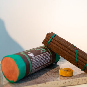 Tybetańskie kadzidła Himalayan Coffee - zestaw kadzideł i podstawka, leżą na glinianej tacy w kropki oparte o tubę z papieru czerpanego.