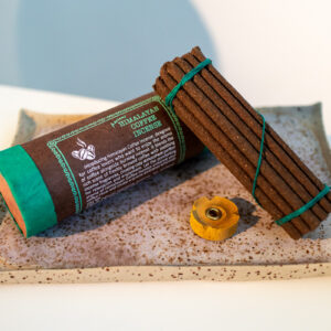 Tybetańskie kadzidła Himalayan Coffee - zestaw kadzideł i podstawka, leżą na glinianej tacy w kropki oparte o tubę z papieru czerpanego.