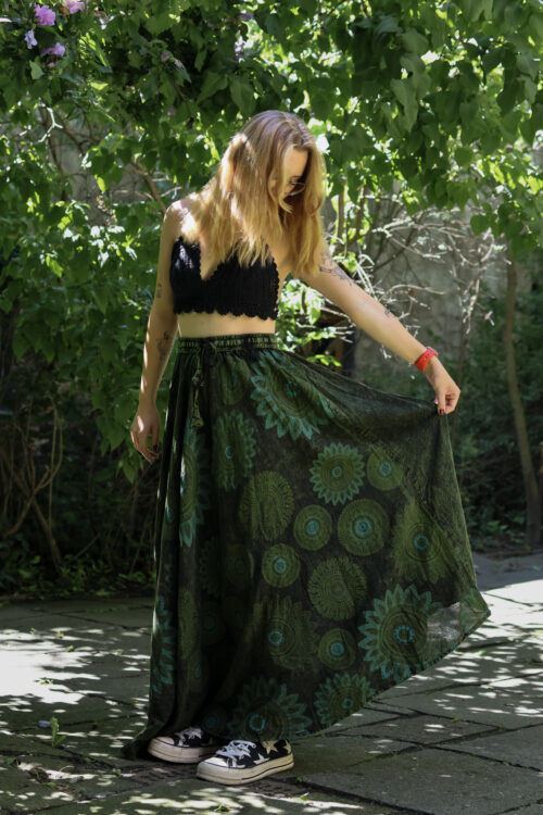Spódnica w mandale Kobieta w blond włosach i czarnym szydełkowym topie w zielonej maxi spódnicy w mandale