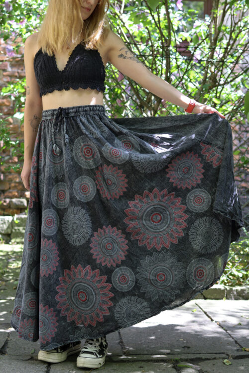 Spódnica w mandale Kobieta w blond włosach i czarnym szydełkowym topie w szarej maxi spódnicy w mandale na tle zieleni