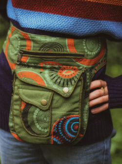 Kobieta w swetrze w paski z biodrówką w kolorze zielonym z nadrukiem w mandale