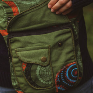 Kobieta w swetrze w paski z biodrówką w kolorze zielonym z nadrukiem w mandale