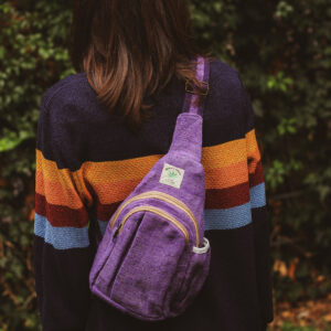 Kobieta w sweterku w paski ma stoi tyłem z plecakiem na jedno ramię Himalayan Hemp w kolorze fioletowym