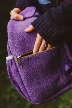 Osoba trzyma fioletowy plecak z konopi Himalayan Hemp