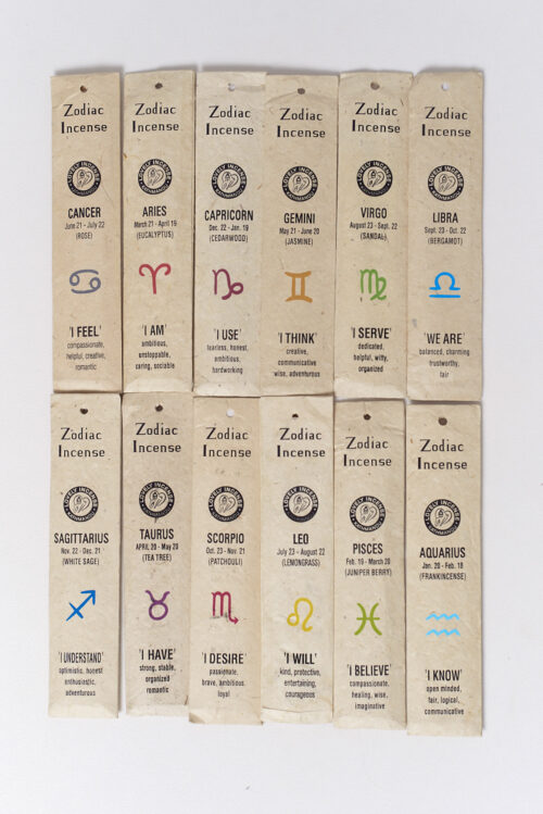 Kadzidła zodiakalne w beżowych opakowaniach z czerpanego papieru leżą na białym tle