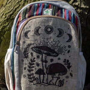 Beżowo niebiesko czerwony plecak z illustracją brązowych grzybów i roślin wykonany z beżowej konopii i kolorowego materiału gheri na tle drzewa