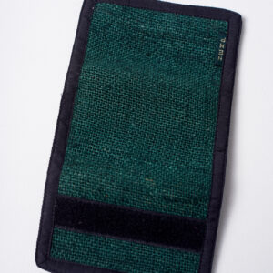 Tył zielonego portfela konopnego, częściowo rozłożony, z widocznym czarnym rzepem na krawędzi, na białym tle