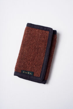 Brązowy portfel konopny z czarnymi elementami wykończenia, na białym tle