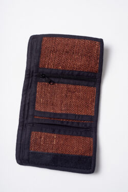 Wnętrze brązowego portfela konopnego z czarnymi elementami wykończenia, trzema mniejszymi kieszeniami, w tym jedną na zamek, oraz jedną dużą kieszenią na białym tle