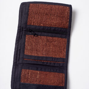 Wnętrze brązowego portfela konopnego z czarnymi elementami wykończenia, trzema mniejszymi kieszeniami, w tym jedną na zamek, oraz jedną dużą kieszenią na białym tle