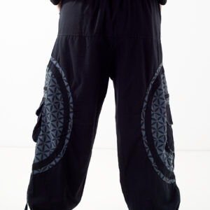 Osoba stoi tyłem na białym tle w czarno-szarych spodniach cargo z dużymi kieszeniami i kwiatowym wzorem