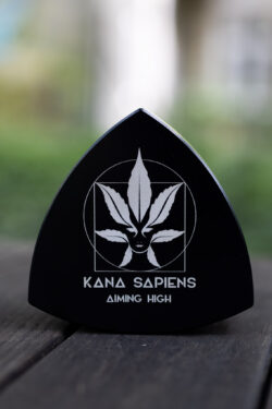 Grinder Przód dużego czarnego trójkątnego grindera z logo Kana Sapiens na tle zieleni