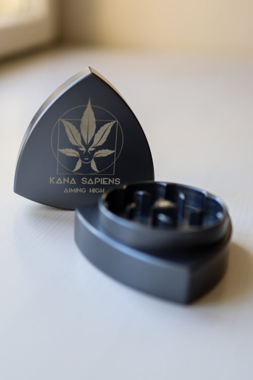 Grinder szary otwarty szary duży grinder z logiem Kana Sapiens na białym stole